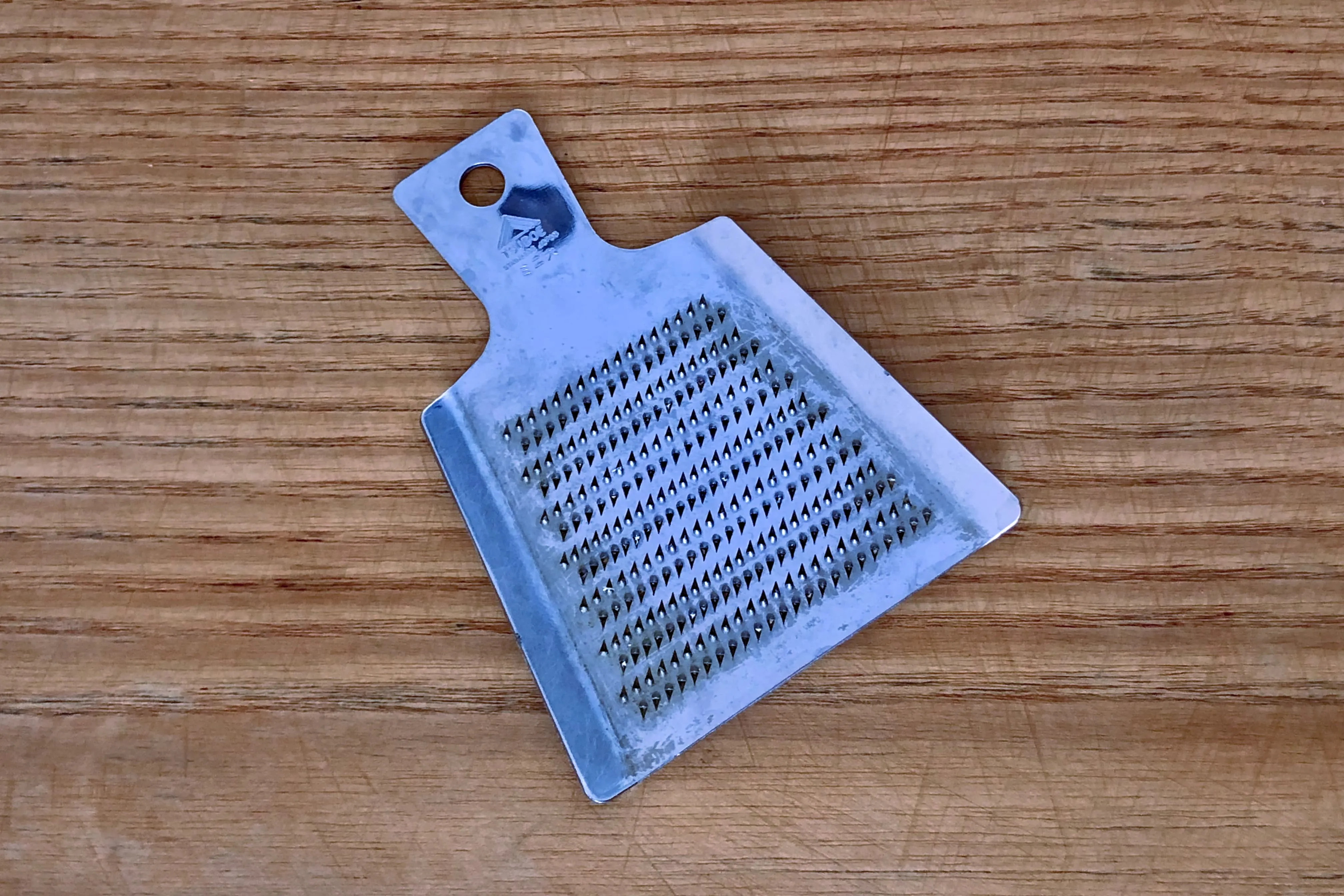 A metalic root vegetable grater